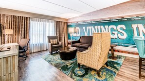 A hotel room with a large window, a sofa, a chair, a coffee table, and a rug. - Hotel Indigo Atlanta-Vinings Ballpark Area by IHG (Atlanta)