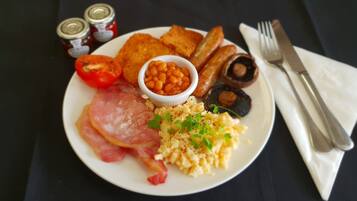 En tallerken med morgenmad, herunder æg, bacon, tomater, bønner, svampe og ristet brød.