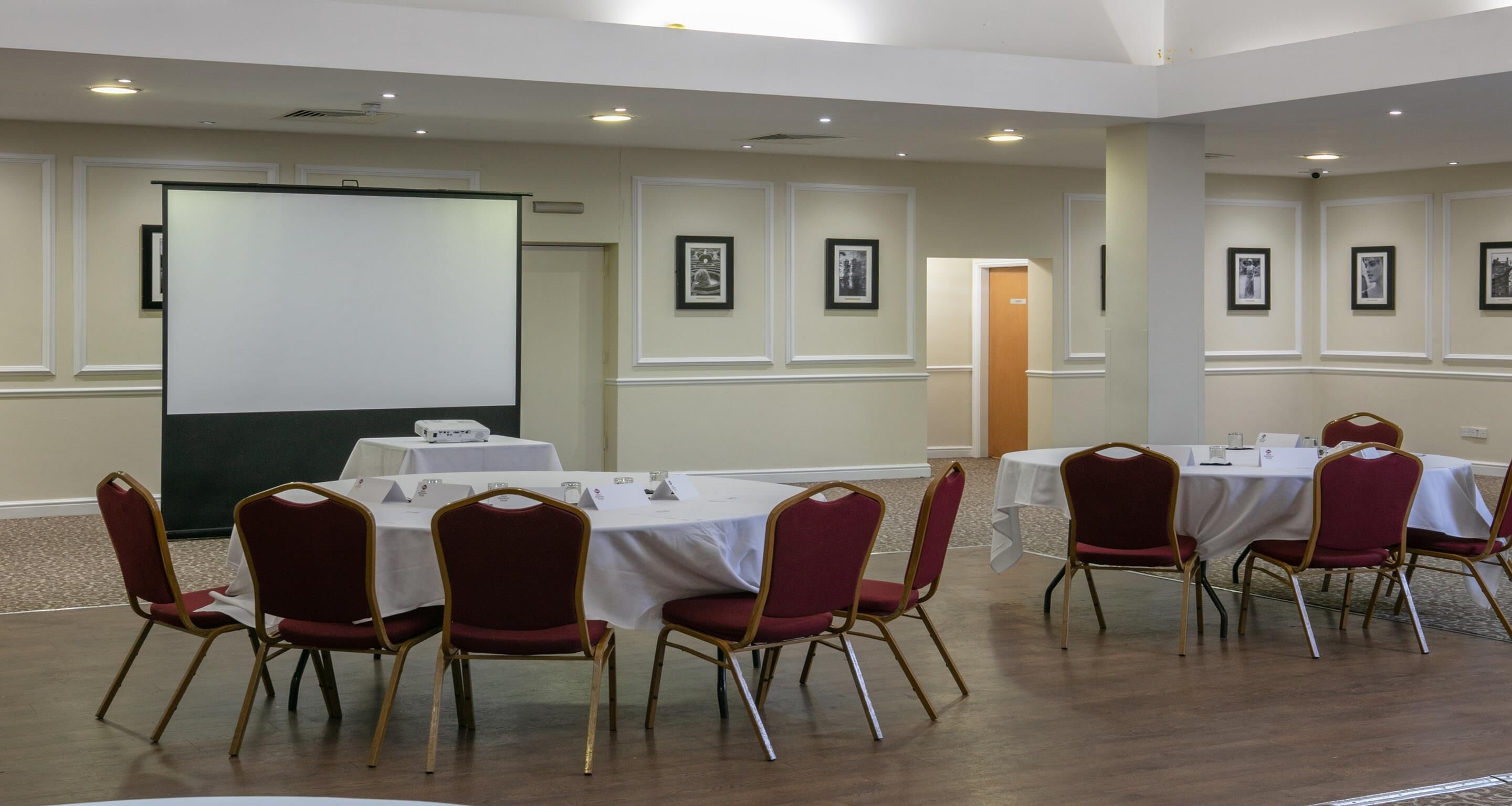 A conference room with a whiteboard, tables, and chairs.