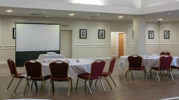 A conference room with a whiteboard, tables, and chairs.