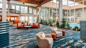 Un hall d’entrée spacieux avec un grand espace salon, une piscine et une vue sur l’intérieur du bâtiment.