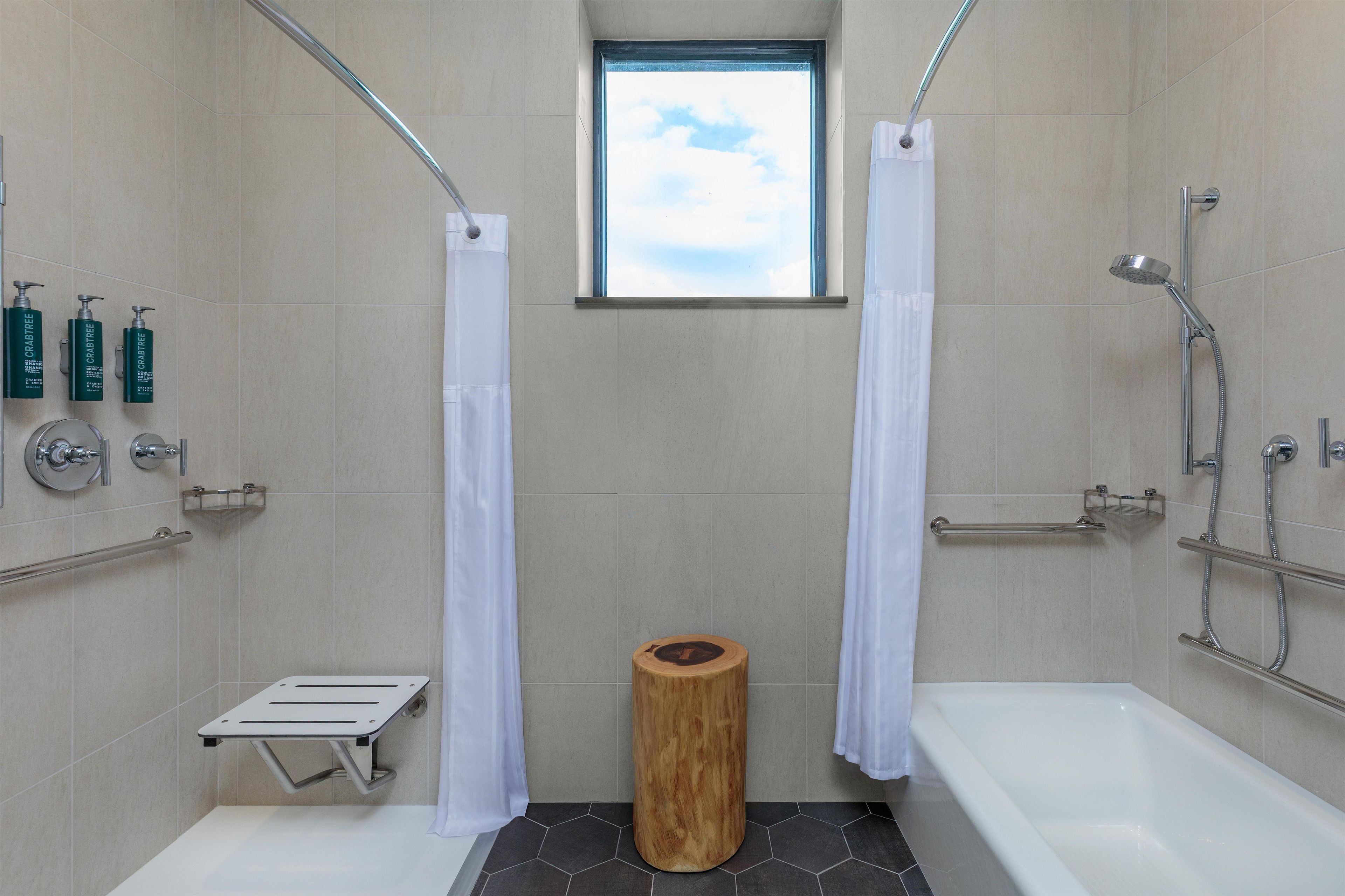 Un baño moderno con bañera, ducha y ventana.