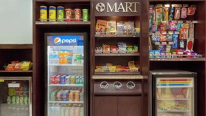 Máquina expendedora llena de diversas bebidas y aperitivos, incluyendo Pepsi y otras gaseosas.