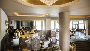 A spacious lobby with a grand chandelier, a bar area, and seating arrangements. - Hotel Tres Reyes Pamplona (Pamplona)