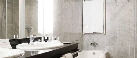 A modern bathroom with a double sink, a bathtub, and a walk-in shower.