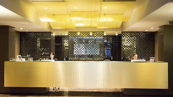A reception desk with a modern design, featuring a central light fixture and decorative panels.