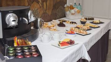 En buffet med forskellige retter, en kaffemaskine og en skål med frugt.