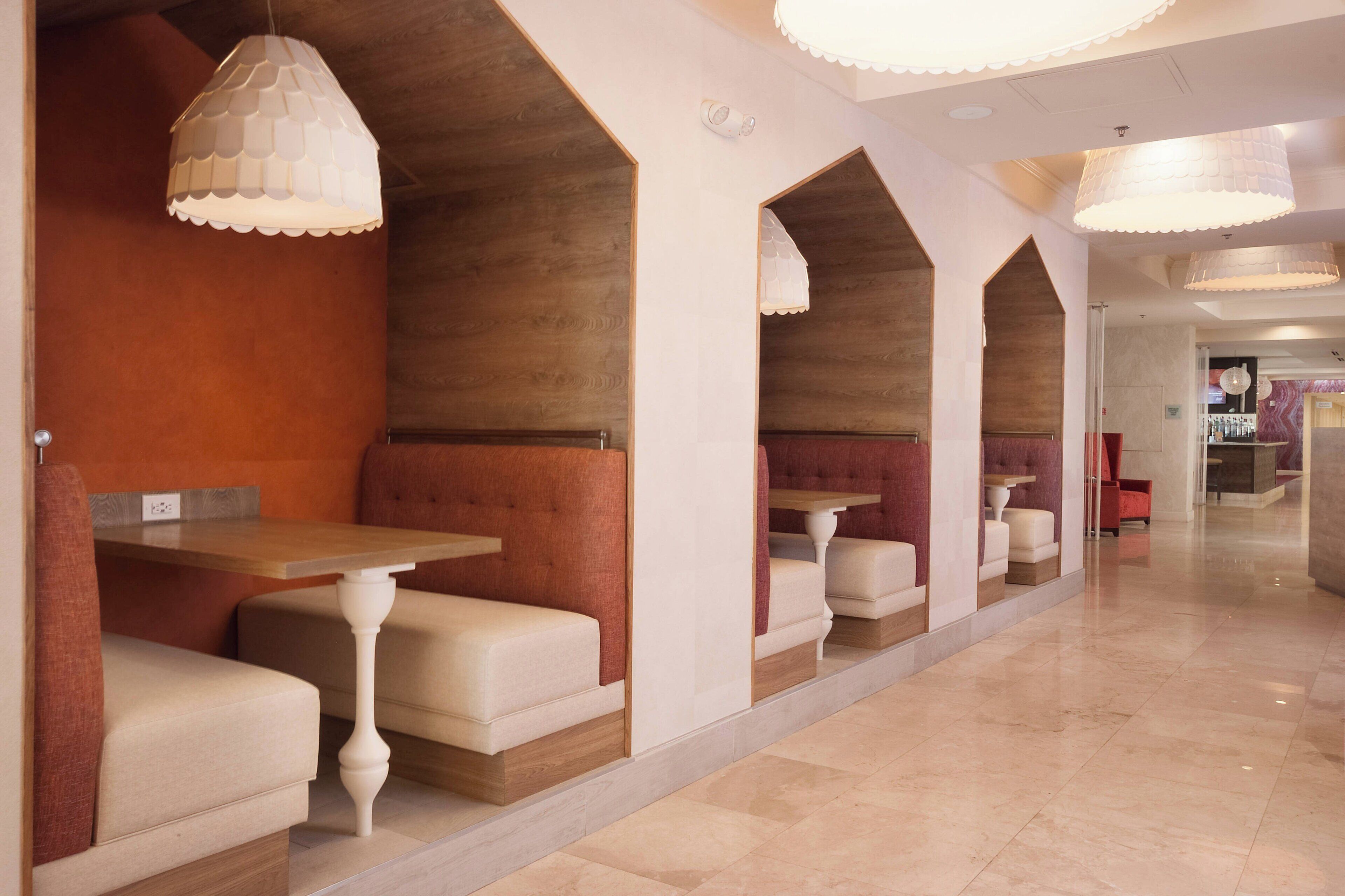 A modern interior with seating areas, wooden accents, and pendant lighting.