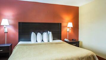 Habitación de hotel con una cama grande, dos mesitas de noche y un cabecero.