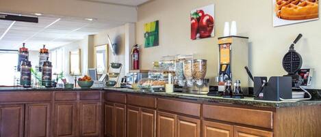 A breakfast bar with coffee machines, food dispensers, and a waffle maker.