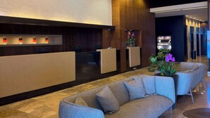 A modern lobby with a reception desk, seating area, and a plant. - The Dan Carmel Hotel (Haifa)