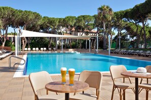 Una piscina al aire libre de temporada, sillones reclinables de piscina