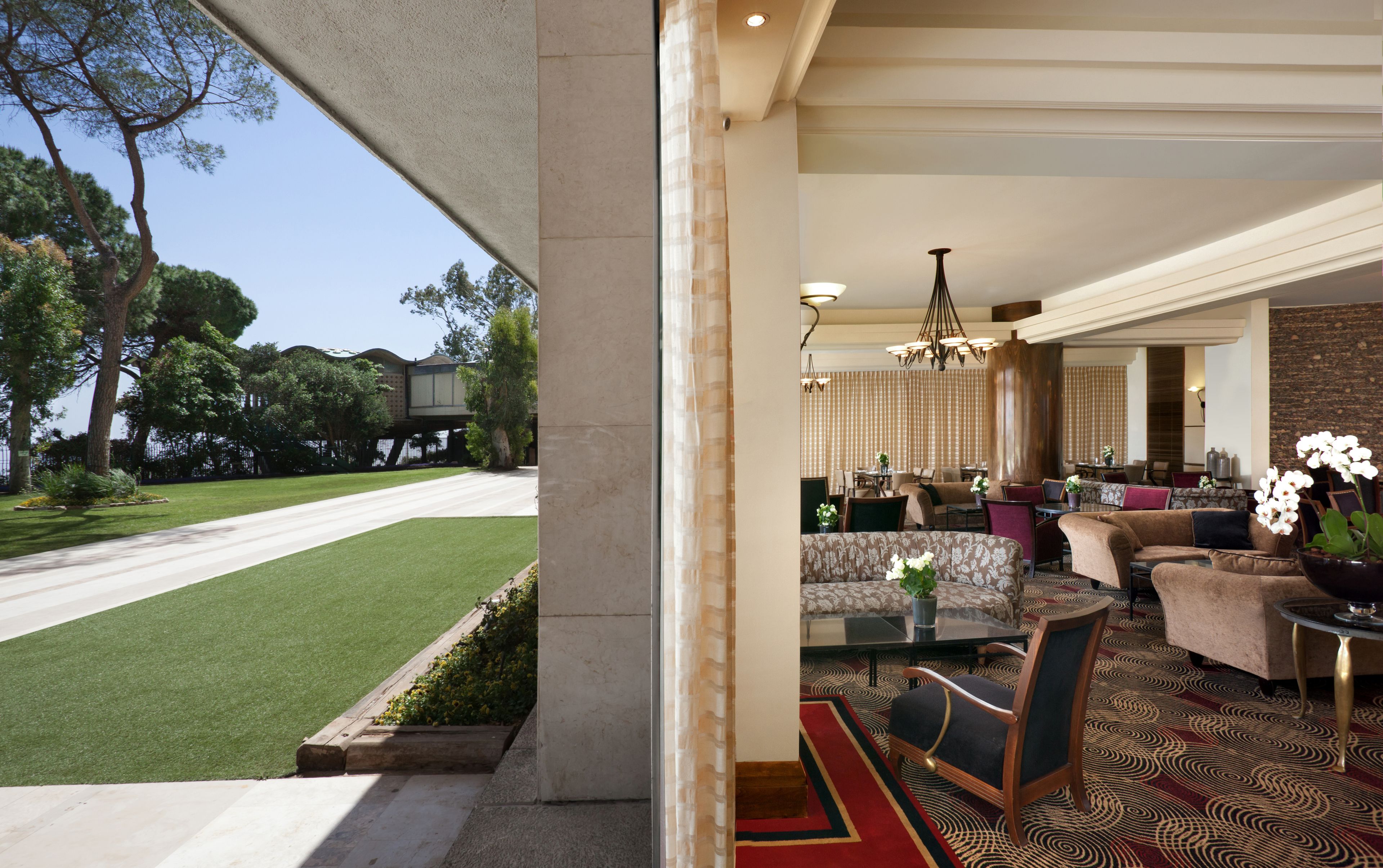 A spacious living area with a view of a well-maintained lawn and trees.