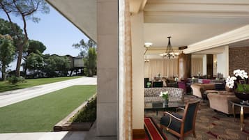A spacious living area with a view of a well-maintained lawn and trees.