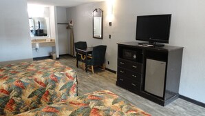 A hotel room with two beds, a desk, a chair, a television, a microwave, and a small refrigerator. - Western Inn (Pensacola)