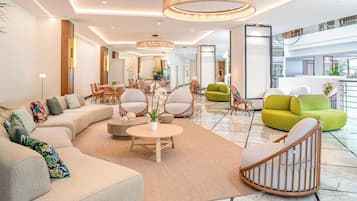 A spacious living area with a sofa set, a round coffee table, and a variety of chairs.