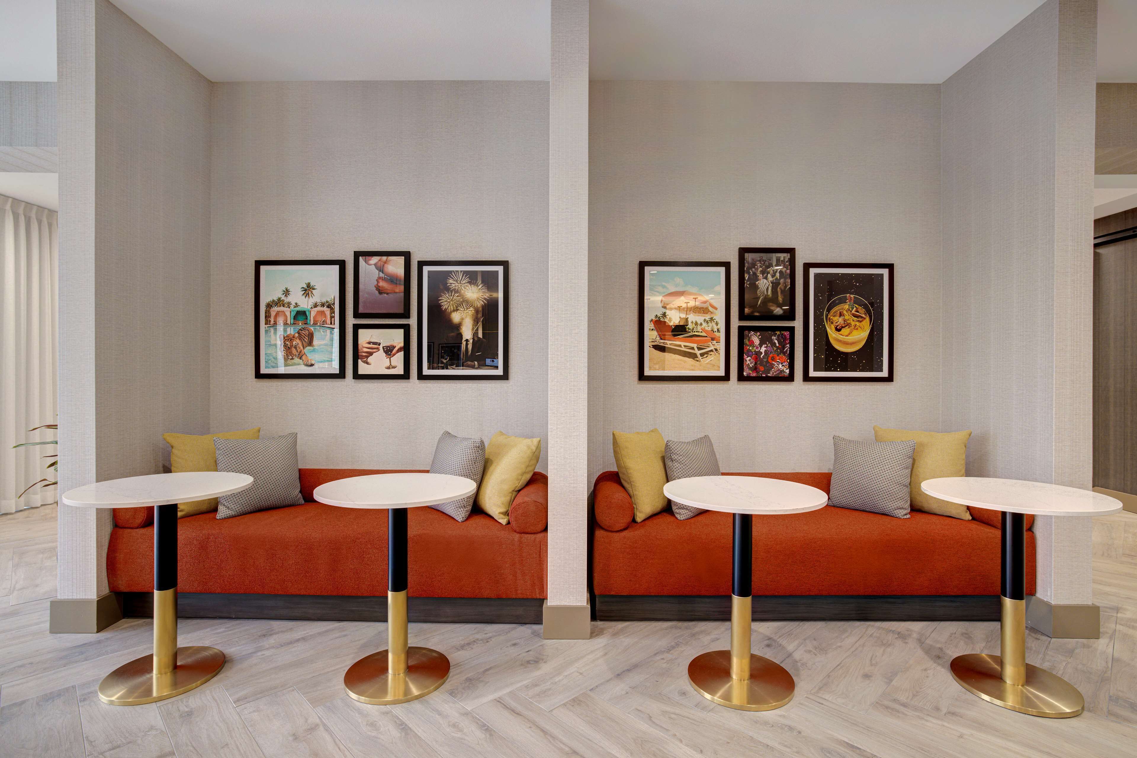 A modern living room with two sofas, a coffee table, and a wall adorned with framed artwork.