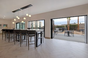 A modern kitchen with a dining area, large windows, and an outdoor patio.