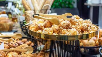A buffet with various baked goods including pastries and bread.
