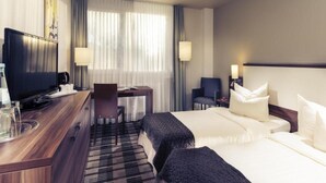 A hotel room with a bed, a desk with a chair, a television, and a window with curtains. - Sunday Hotel Saarbrücken Süd (Saarbrücken)