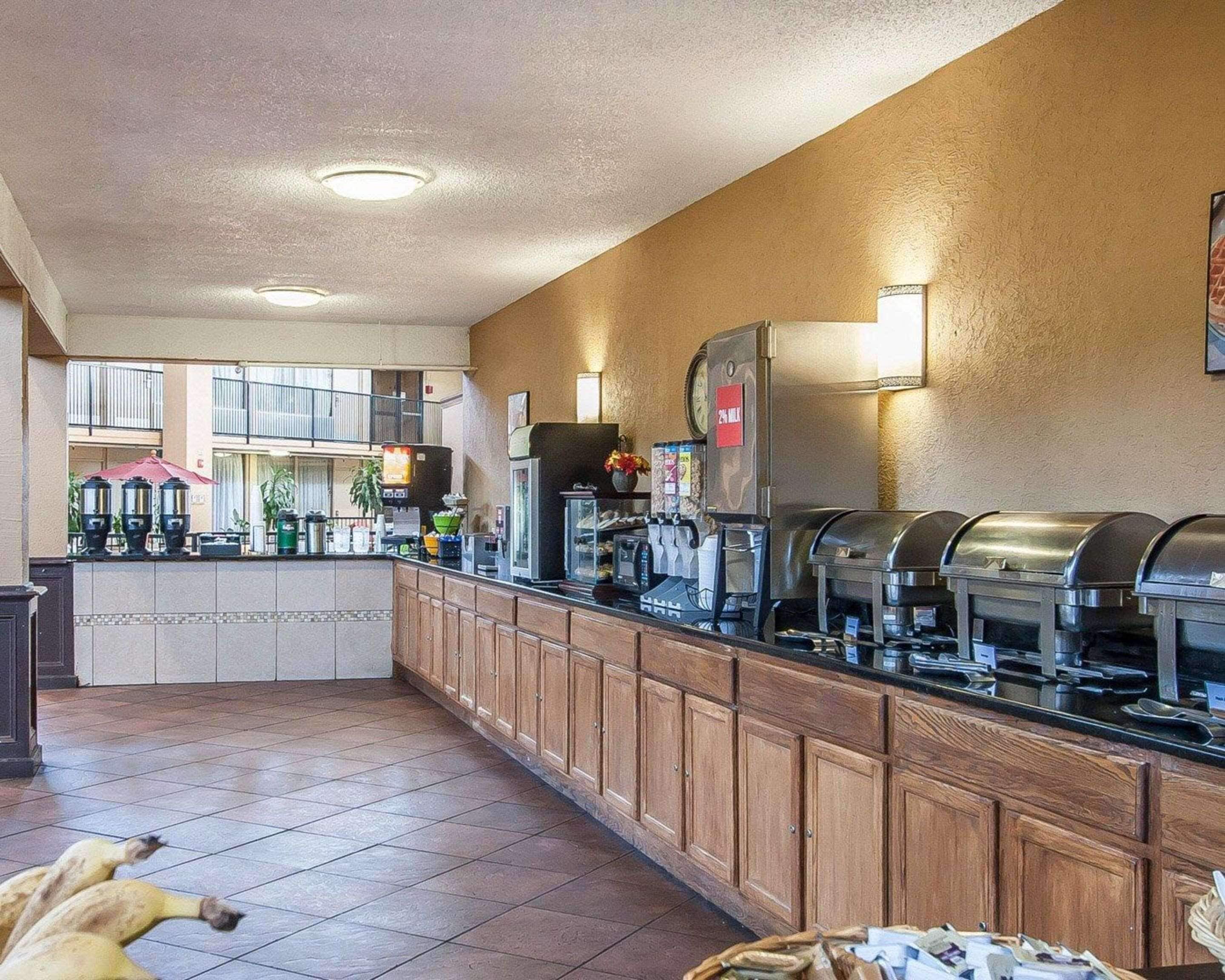 A buffet area with a counter, coffee machines, and a refrigerator.