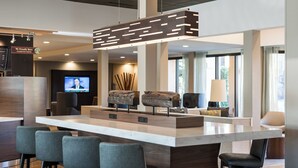 Un espace bar moderne doté d’un grand îlot central, de tabourets de bar, d’un écran de télévision et d’un élément décoratif en bois.