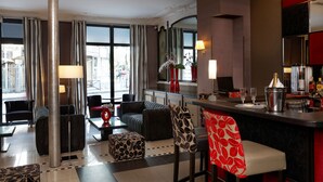 A modern hotel lobby with a bar area, seating arrangements, and a large window offering a view of the street. - Hotel Eiffel Seine (Paris)