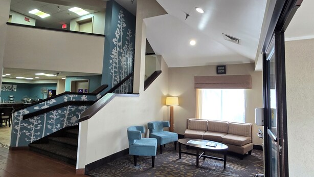 A hotel lobby with a staircase, seating area, and a dining area. - Sleep Inn Chattanooga Hamilton Place (Chattanooga)