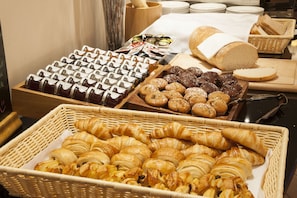Indulge in a self-service breakfast spread featuring an assortment of pastries, bread, and desserts.