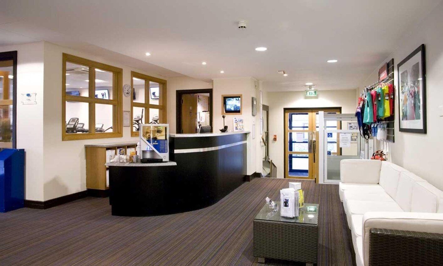 A reception area with a counter, seating, and a wall-mounted TV.