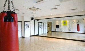 Exercise and train in this room, featuring a punching bag and a clock.