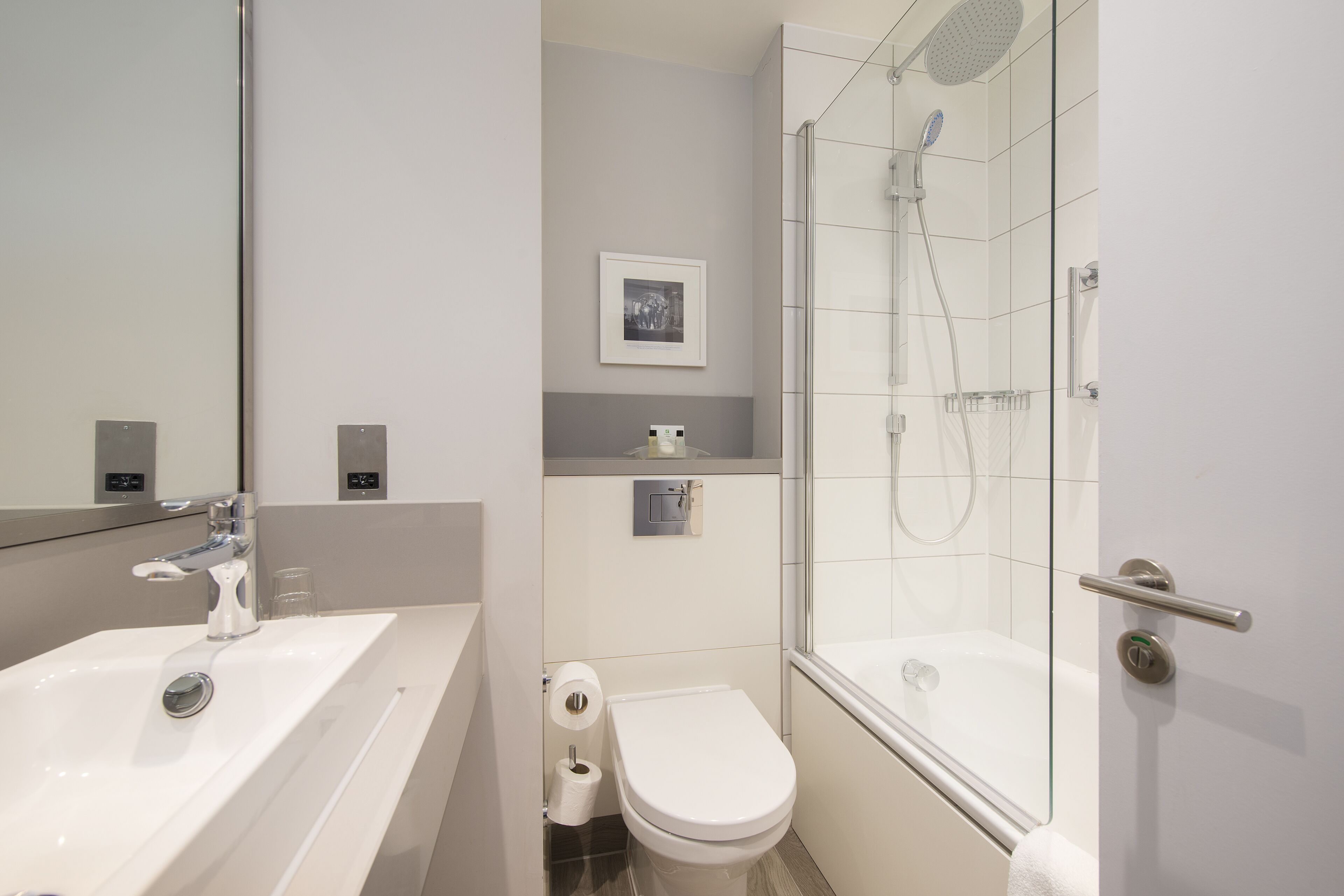 A modern bathroom with a sink, toilet, and glass-enclosed shower.