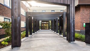 A covered walkway with a modern architectural design, connecting two buildings. - Holiday Inn London - Shepperton by IHG (Shepperton)