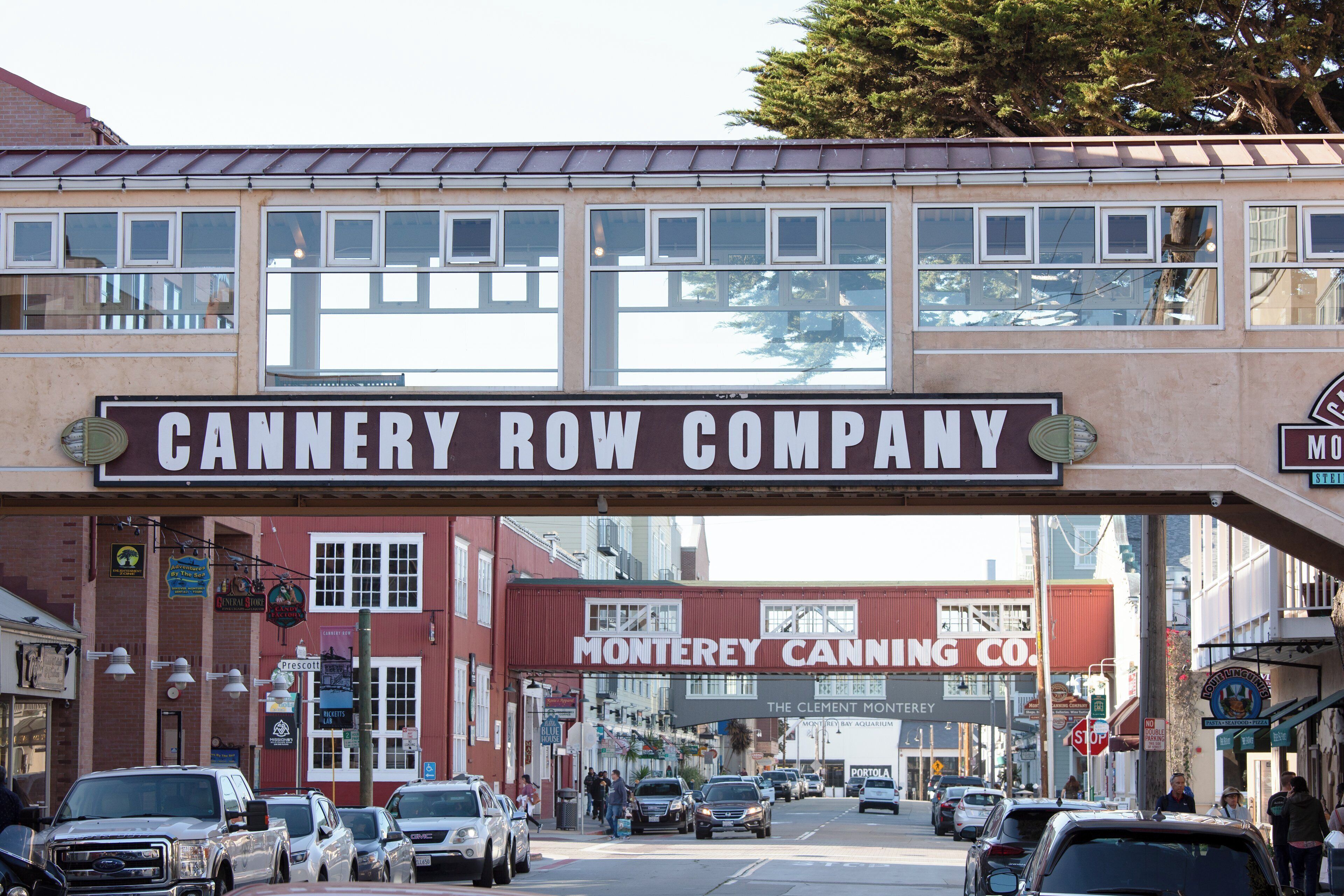 Una calle con un cartel grande para Cannery Row Company y Montyrey Canning Co.