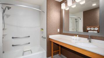 Un baño moderno con ducha, lavamanos y espejo.