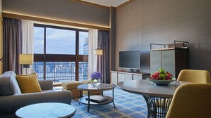 A hotel room with a large window, a flat-screen TV, a dining table, and a sofa. - Artyzen Grand Lapa Macau (Macau)