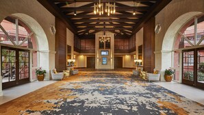 A spacious lobby with a patterned carpet, wooden ceiling beams, and a central chandelier. - Hilton Phoenix Resort at the Peak (Phoenix)