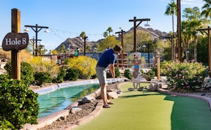 A miniature golf course with a sign for 'Hole 8' and a person playing. - The Peak Phoenix, a Hilton Resort (Phoenix)