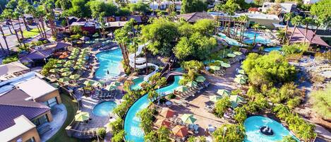 A resort with multiple swimming pools, palm trees, and lounge areas.