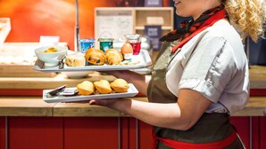 A person holding a tray with pastries and a bowl of food. - ibis Paris Pont De Suresnes (Suresnes)