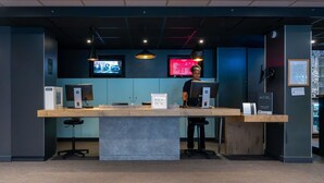 A reception desk with a computer, a sign reading 'KEY BOX,' and a monitor displaying a red screen.