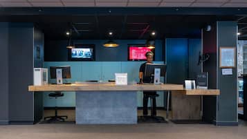 A reception desk with a computer, a sign reading 'KEY BOX,' and a monitor displaying a red screen.