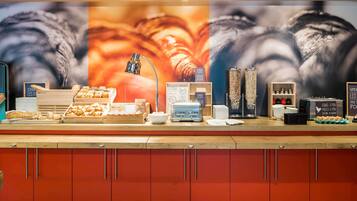 Un bufé de desayuno con diversas opciones de comida y una estación de café.