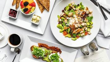 A breakfast setting with toast, fruit, a salad, and a menu.