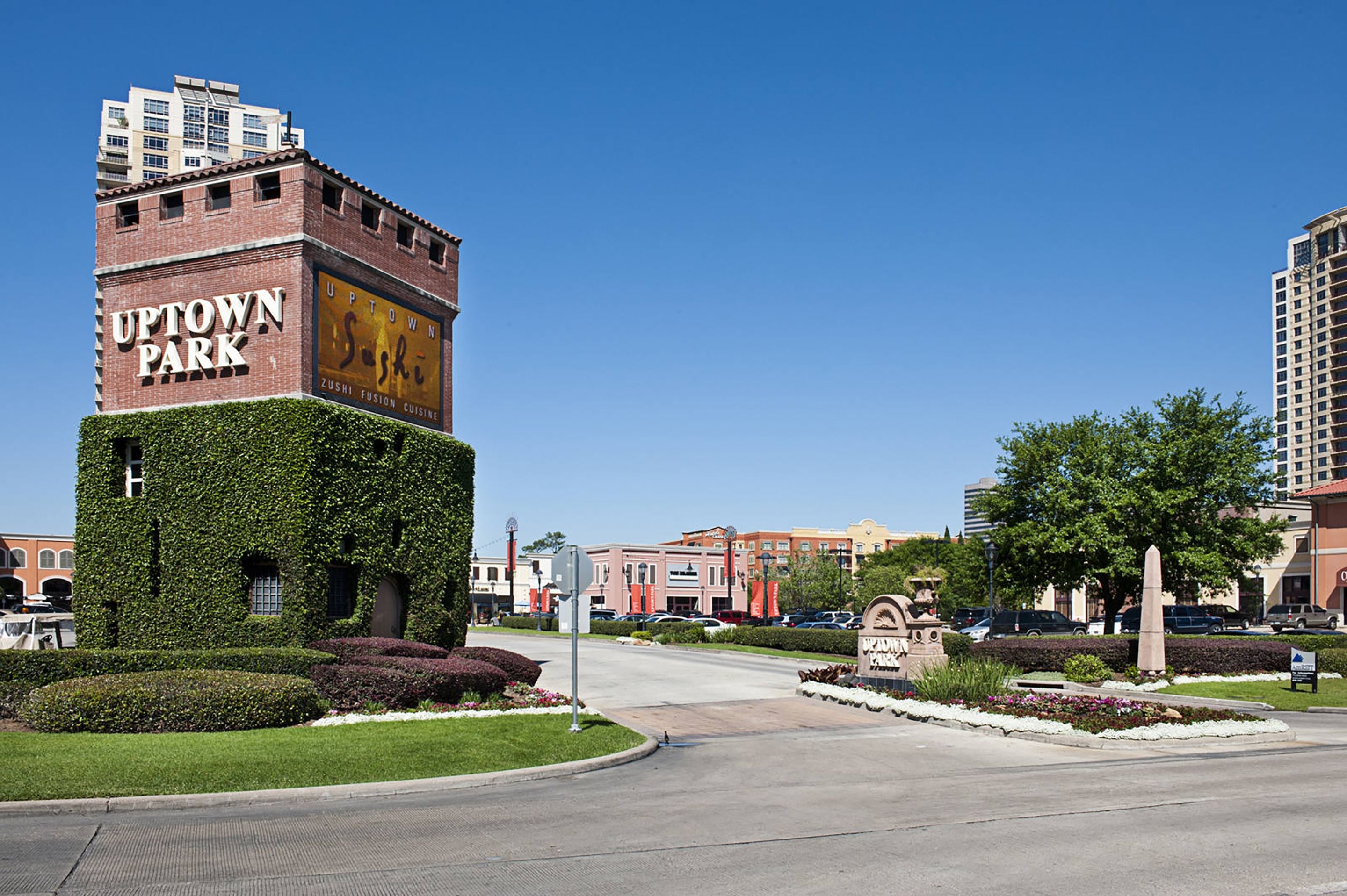 A building with a clock tower labeled "UPTOWN PARK" and a sign for "Sushi Fusion Cuisine."