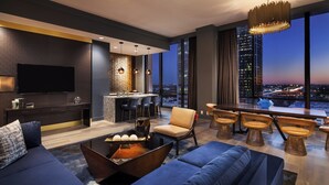 Un salon moderne avec un grand canapé, une table basse et un coin repas avec des chaises.