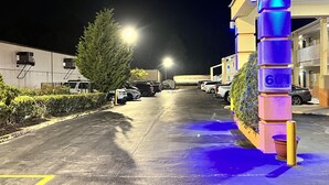 A parking lot with cars and a building with a sign reading "601 Frontage Rd. NW". - Rodeway Inn Augusta West - Fort Gordon (Augusta)