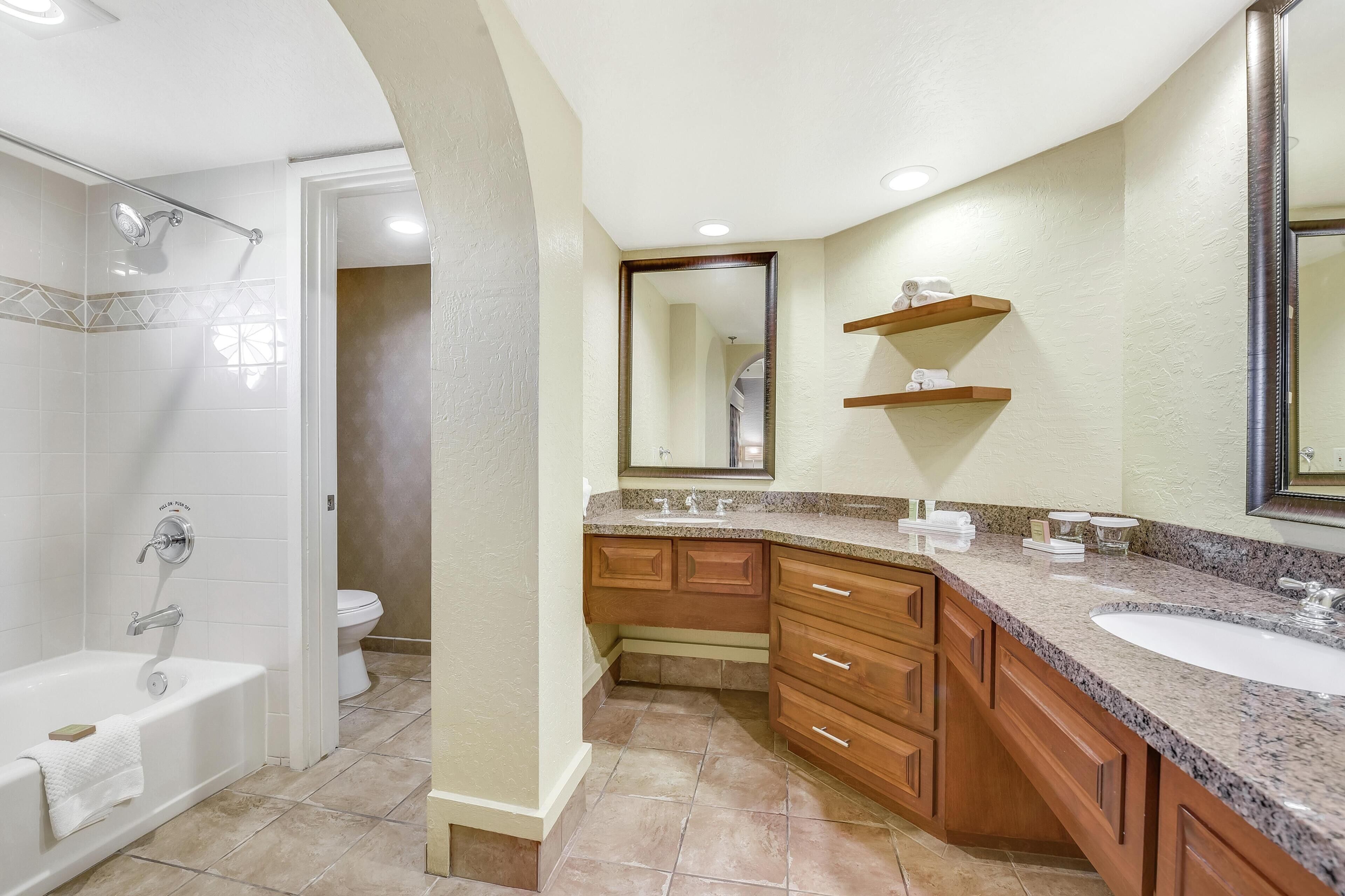 Une salle de bain équipée d’une douche, de toilettes, d’un meuble-lavabo et d’un miroir.