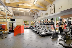 A gym with treadmills, exercise balls, and a staircase.