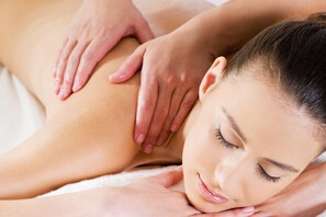 A person receiving a massage, focusing on the back and shoulder area.